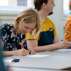 Student van de PThU maakt notities tijdens een college.