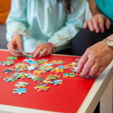 Twee mensen zijn samen een puzzel aan het maken.