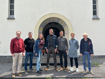 De deelnemers van de studiereis poseren voor de ingang van het klooster van Chevetogne.